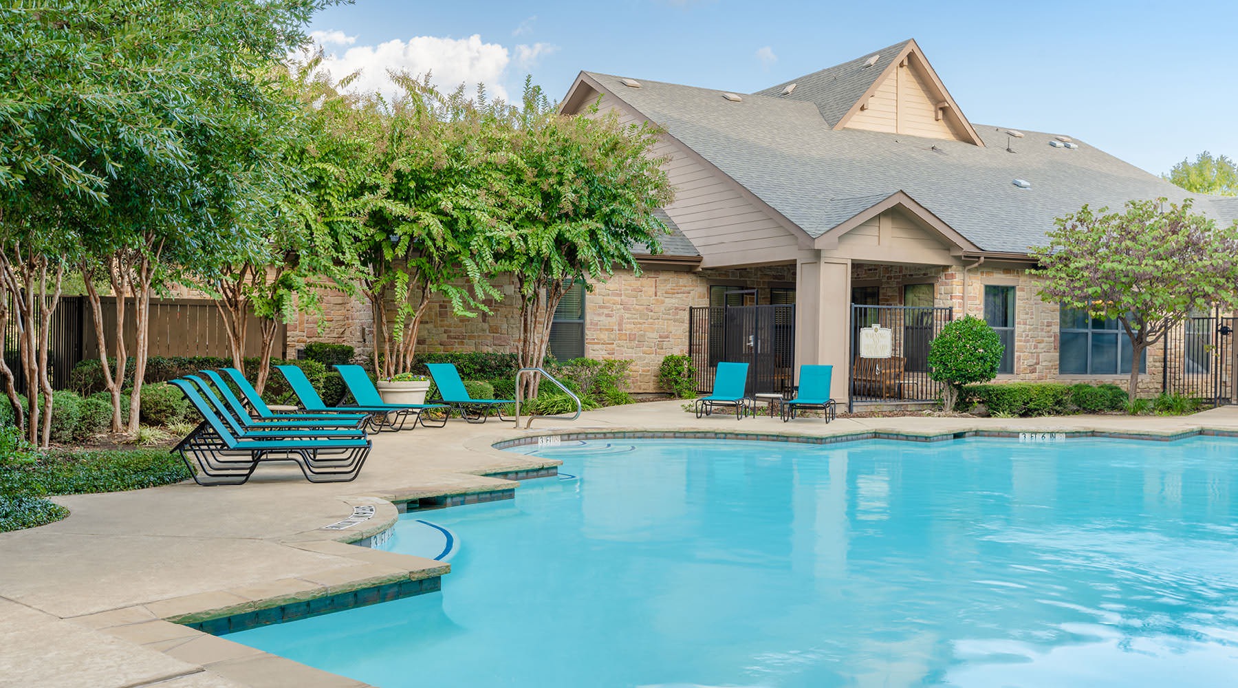 Relax and unwind poolside a swimming pool in front of a clubhouse